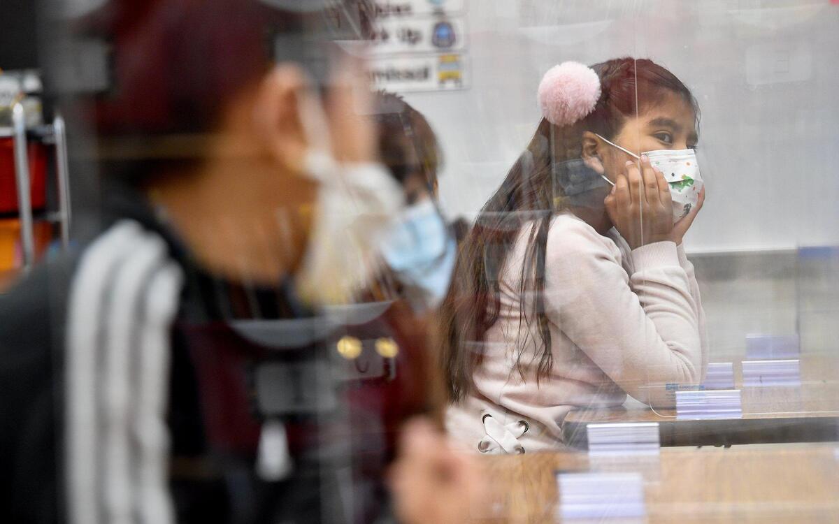 From behind her desk partition, first grader Zury Mendoza listens to her teacher Marion Heck. Students arrived at Douglass Elementary School in Kansas City, Kansas, Wednesday, March 31, 2021, for the first day of full in-person learning. According to Principal Louis Neal, about 75 percent of students are coming back for in-person learning.