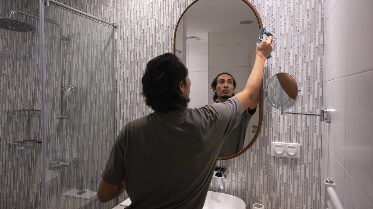 Bathroom mirror being cleaned.