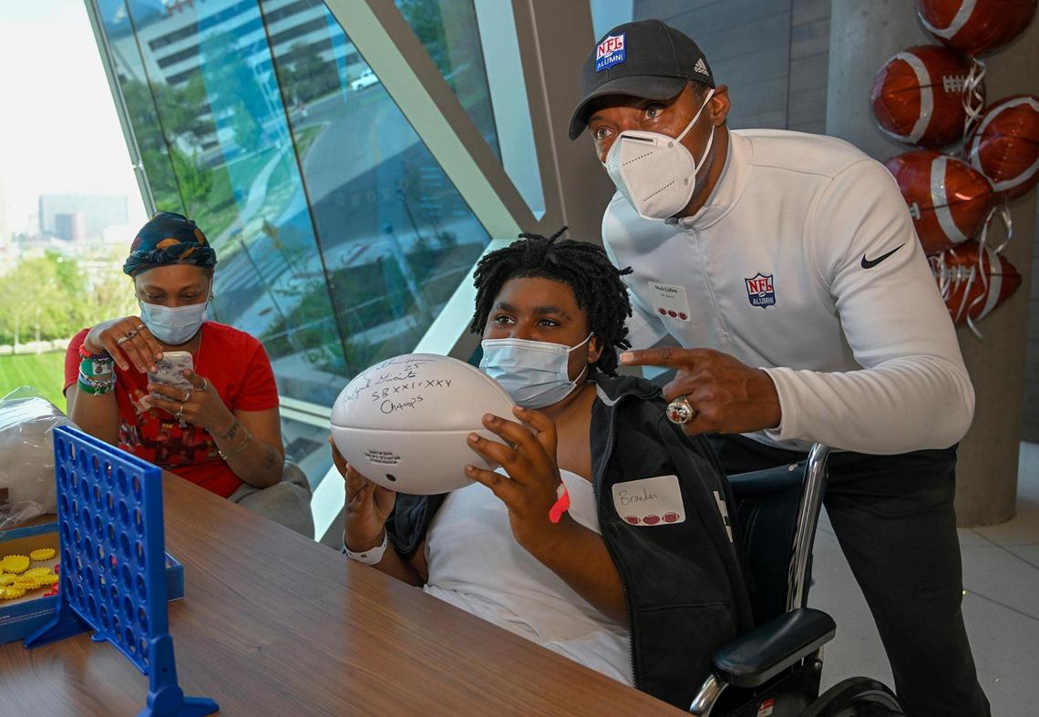 Former NFL player Mark Collins, who played with the Chiefs from 1994 to 1996, autographed a football and took a photo with Brandon Smith, 13, of Kansas City.