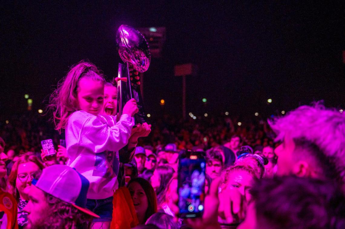 Two young fans hold the Vince Lombardi Trophy while Loud Luxury performs at Kelce Jam at the Azura Amphitheater on Friday, April 28, 2023, in Bonner Springs.