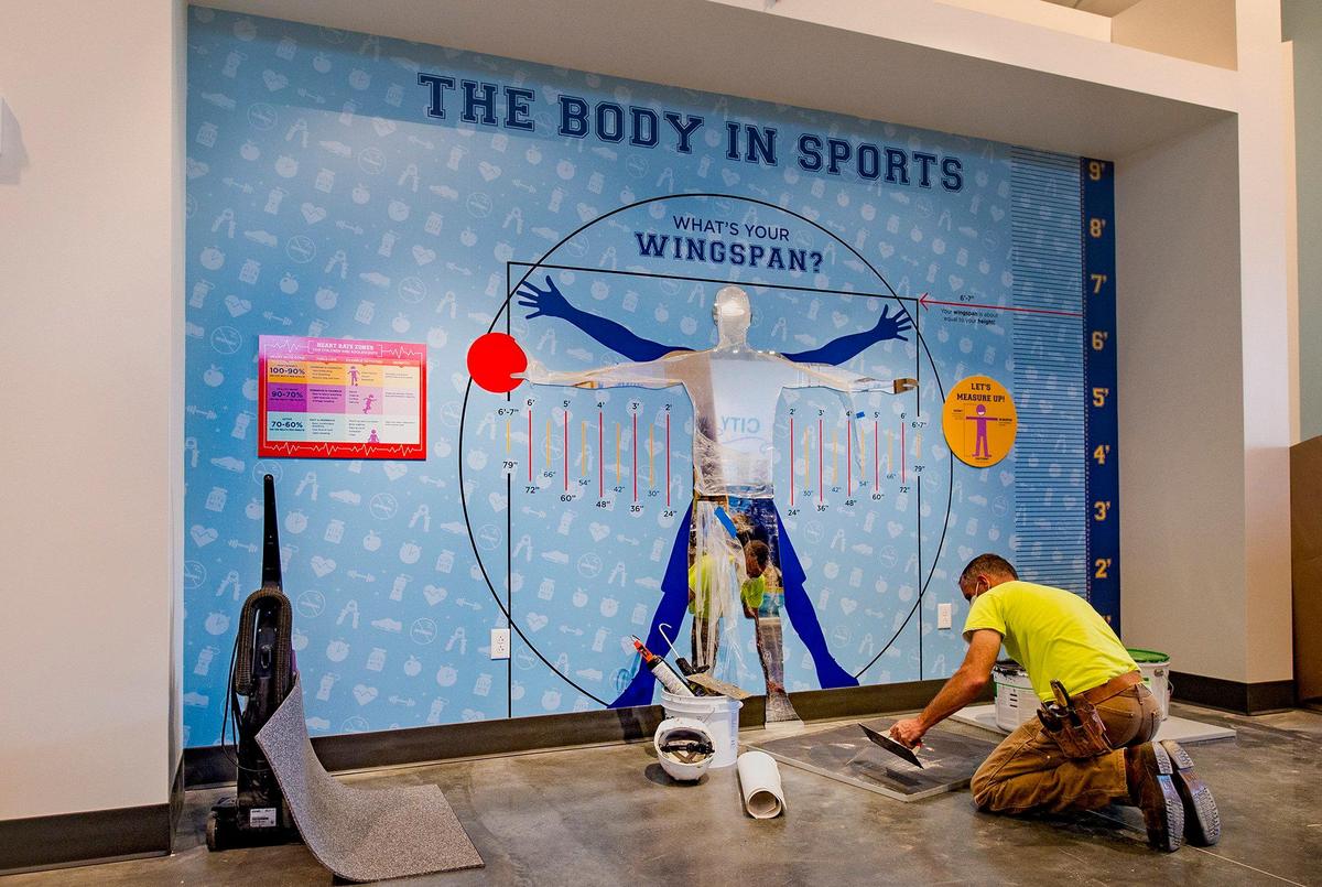 Dustin Spence of Dimensional Innovations of Lenexa added finishing touches to a display in the On the Move! exhibit.