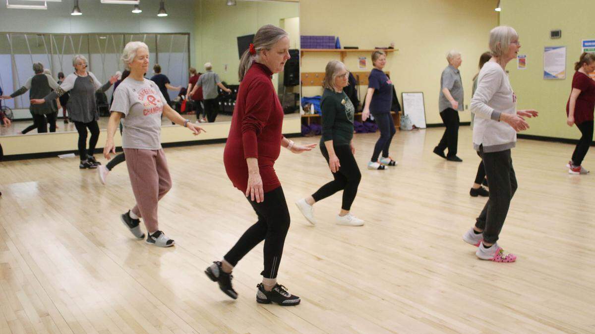 Lyra Pherigo of Olathe gets into the swing of a line dancing class at the Olathe Community Center.