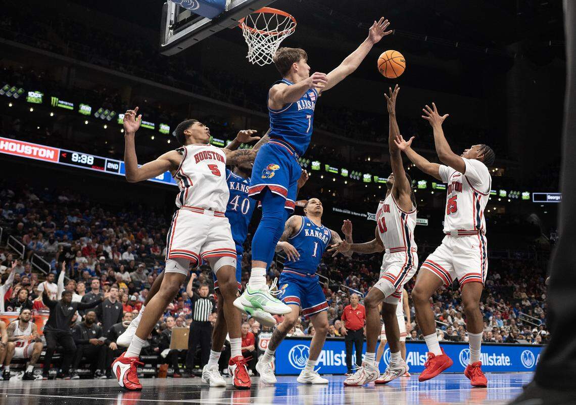Kansas Jayhawks guard Kohl Rosario (7) blocks a shot as Houston Cougars forward Joseph Tugler (11) and others try to rebound the ball during a Big 12 Men's Basketball Tournament semifinal game inside Kansas City’s T-Mobile Center on Friday, March 13, 2026.