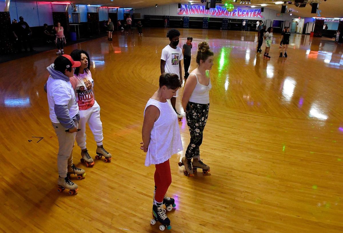 During a fundraiser held Thursday evening at Winnwood Skate Center, Vicenta Guzman, left, the mother of the late Manuel Guzman, joined others in a moment of silence as family and friends gathered to honor the Kansas City teen who was fatally stabbed in a bathroom at Northeast Middle School. Guzman loved to roller skate and dozens of patrons who knew him gathered at the rink to remember him and raise money for his funeral expenses.