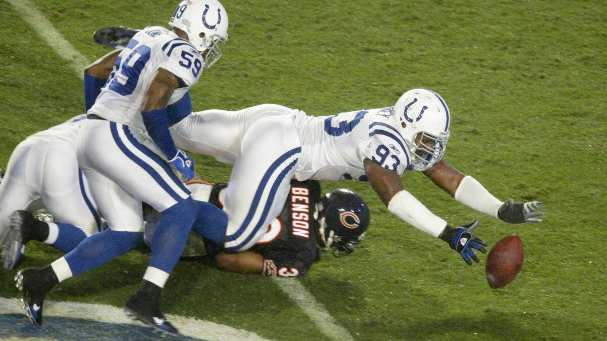 Indianapolis Colts defensive end Dwight Freeney (93) recovers a fumble from Chicago Bears running back Cedric Benson (32) near the end of the first quarter in the Super Bowl XLI football game at Dolphin Stadium in Miami, Sunday, Feb. 4, 2007. (AP Photo/Wilfredo Lee)