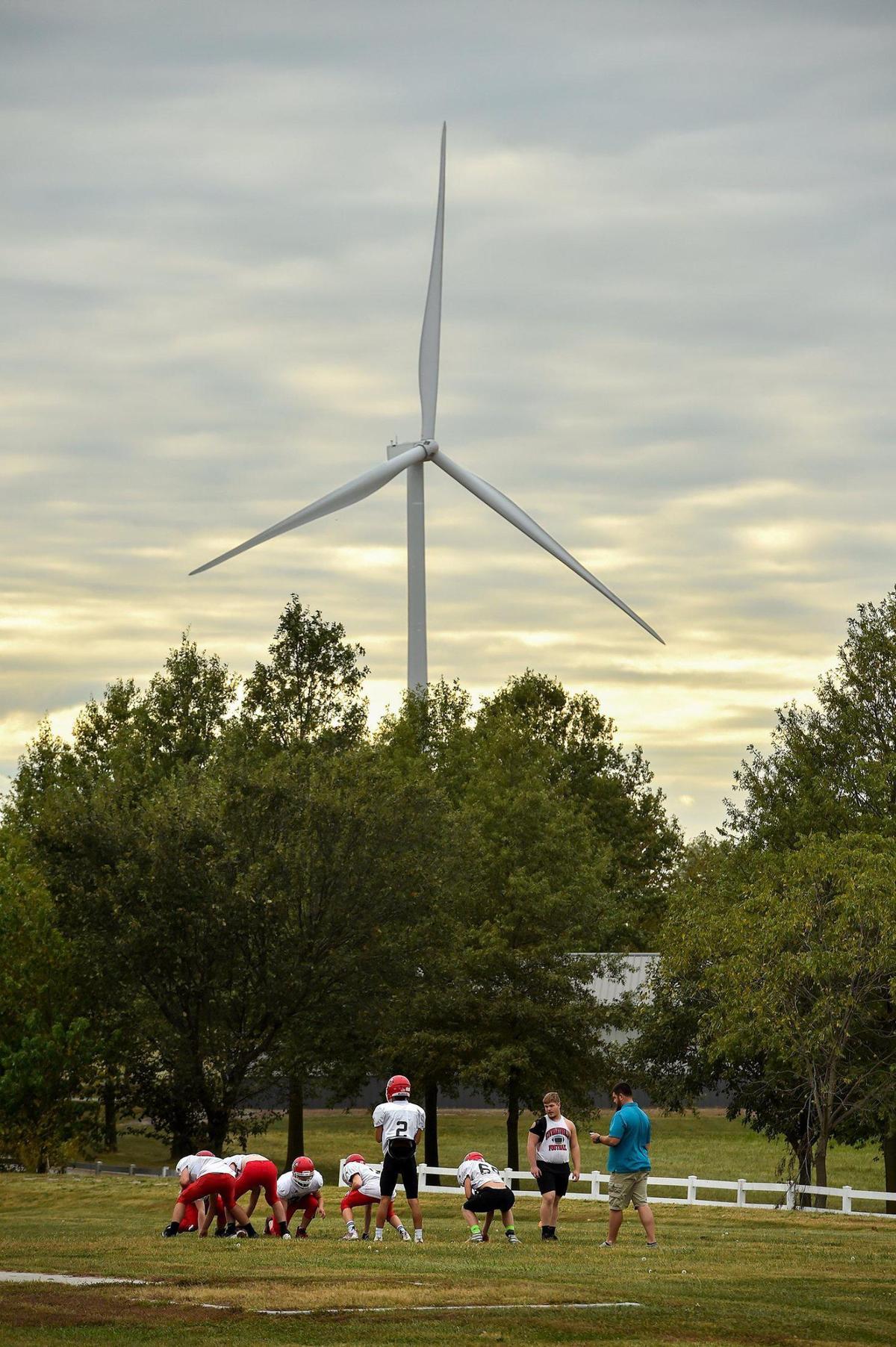 A wind turbine from a nearby wind farm looms over players at football practice in Osborn, Missouri.