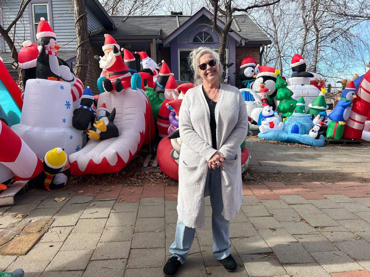 Cindy Stout poses in front of her home on Dec. 3. After 20 years of Paulie’s Penguin Playground, she and her husband are ready to give the inflatables away.