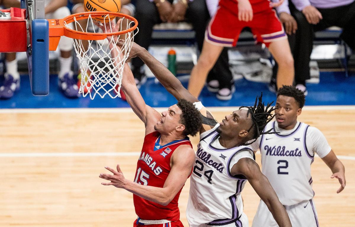 Kansas Jayhawks guard Kevin McCullar Jr. (15) shoots a layup as Kansas State Wildcats forward Arthur Kaluma (24) contests the shot during an NCAA college basketball game on Tuesday, March 5, 2024, in Lawrence.