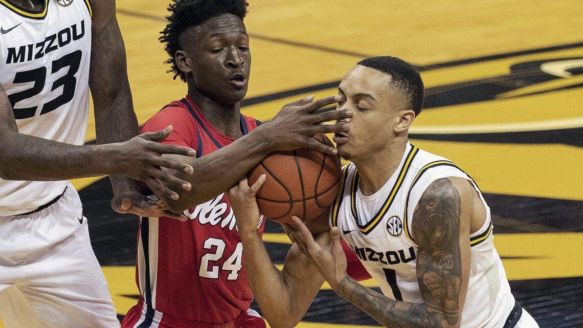 Mississippi’s Jarkel Joiner, left, and Missouri’s Xavier Pinson, right, battle for loose ball during the second half of an NCAA college basketball game Tuesday, Feb. 23, 2021, in Columbia, Mo. (AP Photo/L.G. Patterson)
