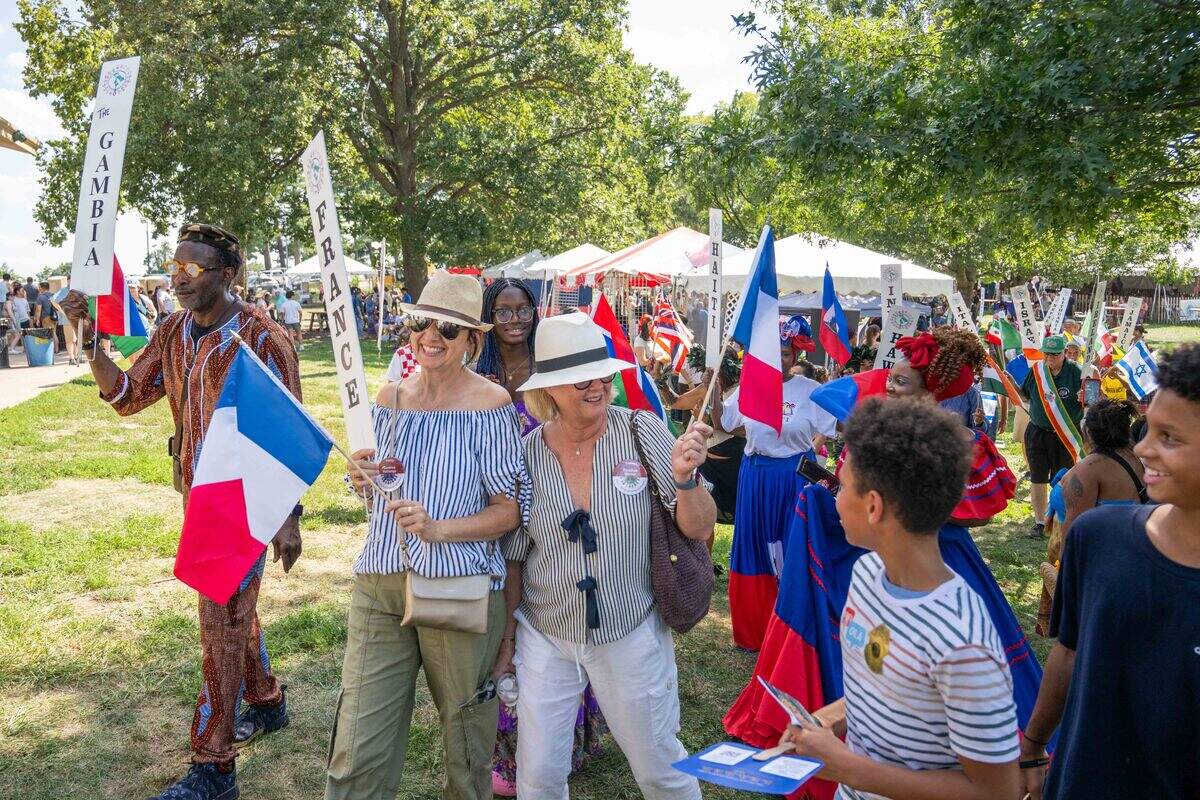 People of different ethnicities participate in the parade of flags at the Ethnic Enrichment Festival in Swope Park on Saturday.