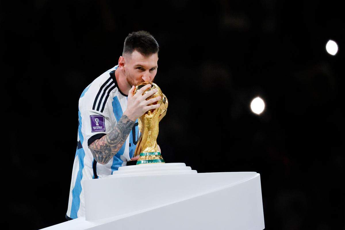 Argentina forward Lionel Messi (10) kisses the World Cup Trophy after winning the 2022 World Cup final against France at Lusail Stadium in Qatar. 