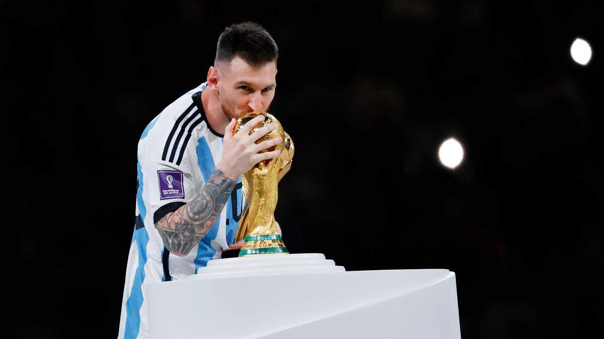Argentina forward Lionel Messi (10) kisses the World Cup Trophy after winning the 2022 World Cup final against France at Lusail Stadium in Qatar. 
