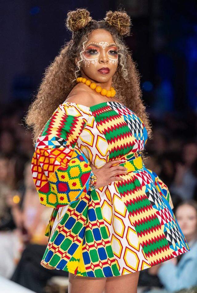 Natasha Edwards wearing a bold, colorful dress made by Kenya Martin featuring fabric with African-inspired geometric prints during Kansas City Fashion Week.