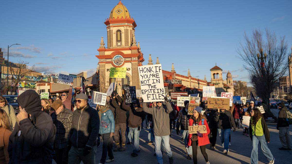 Demonstrators walk along Emanuel Cleaver II Boulevard during a vigil for victims of U.S. Immigration and Customs Enforcement on Saturday, Jan. 10, 2026, in Kansas City.
