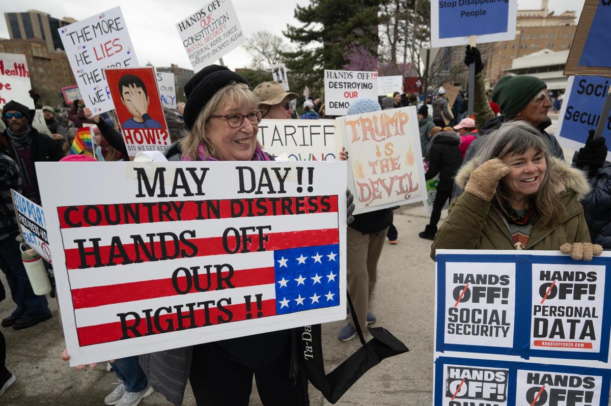 Protesters including Vicki Ryder of Lee’s Summit and Michele Markowitz of Kansas City, joined hundreds for the Hands Off! Kansas City Fights Back on Saturday, April 5, on the Country Club Plaza in Kansas City.