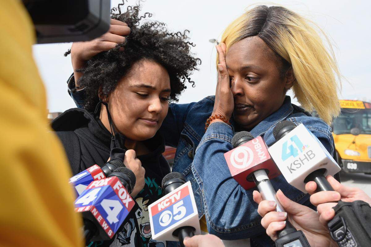 Kamryn Cummings, 14, left, a freshman at Olathe East High School, is hugged by her mother Keicia Stillman at a reunification site after a shooting Friday at the school. Keicia was still waiting for her other daughter to come out of the school.