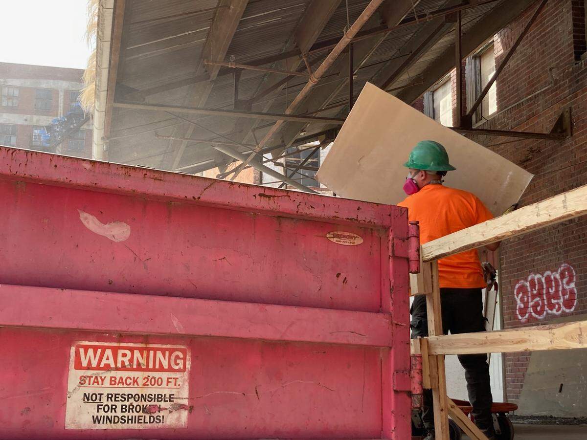 Debris being tossed at the rear of the Moline Plow building, now under renovation as a 121-unit luxury loft apartment building in the West Bottoms.