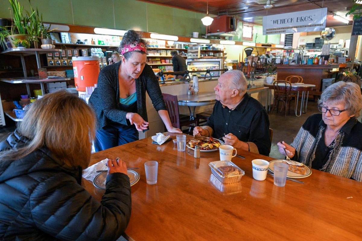 You Say Tomato owner Anne Clark stopped by a table to talk with customers Sandy Mills, left, and her parents, Tom and Nancy Mills before its closure two years ago.