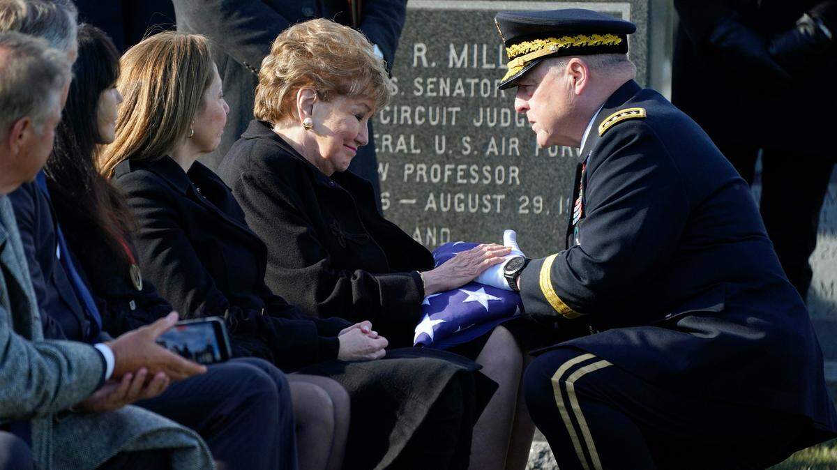 Chairman of the Joint Chiefs of Staff Gen. Mark Milley presents former Sen. Elizabeth Dole a U.S. flag Wednesday during the burial service for her late husband Bob Dole. The former U.S. Senate majority leader and Republican presidential nominee was celebrated as a World War II hero at Arlington National Cemetery. (AP Photo/Evan Vucci)