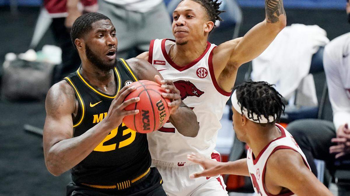 Missouri’s Jeremiah Tilmon (left) is defended by Arkansas’ Ethan Henderson (center) and Moses Moody in the first half of their game in the Southeastern Conference Tournament on Friday, March 12, 2021, in Nashville, Tenn.