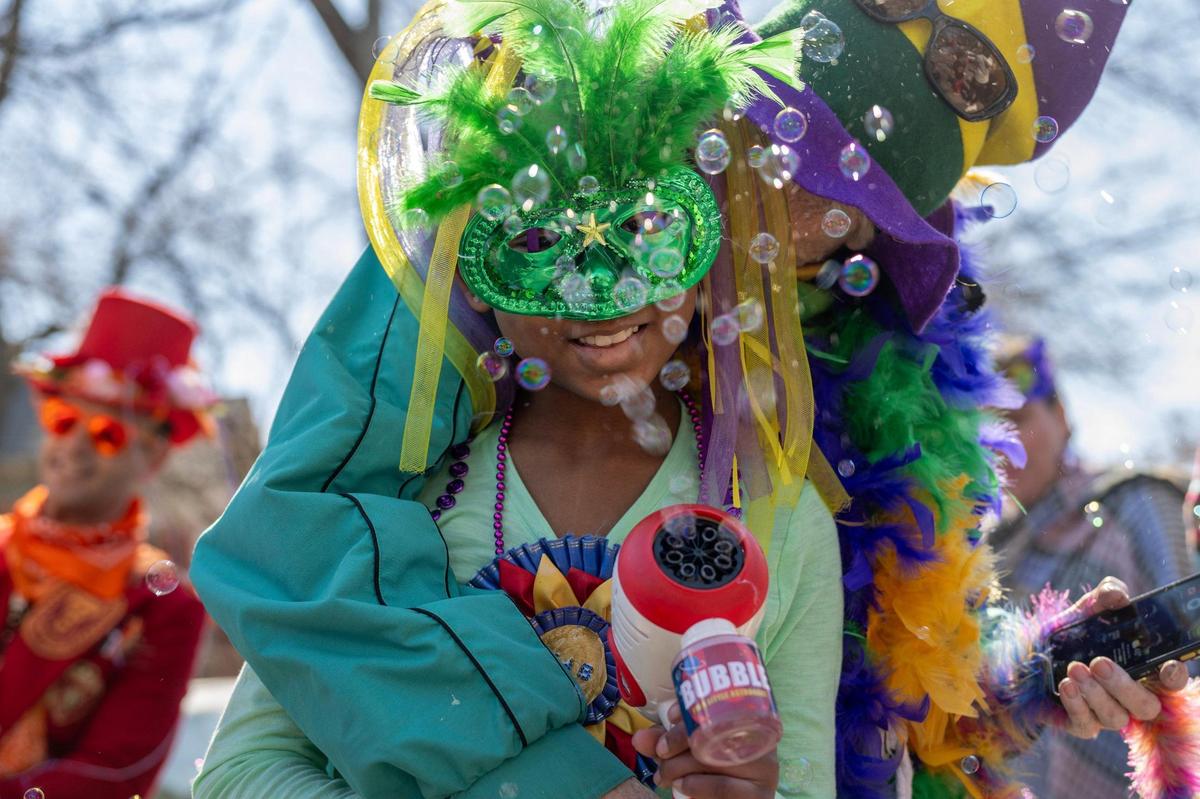 A parade participant operates a handheld bubble machine during the Krewe de Prank parade on Sunday, March 2, 2025, in Kansas City.