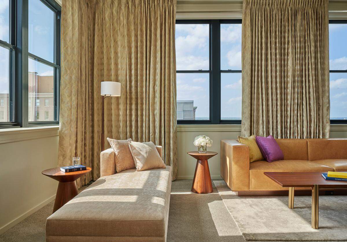 Suites at the new 21c Museum Hotel Kansas City feature gold drapes, sleek leather couches, large windows and pops of purple.