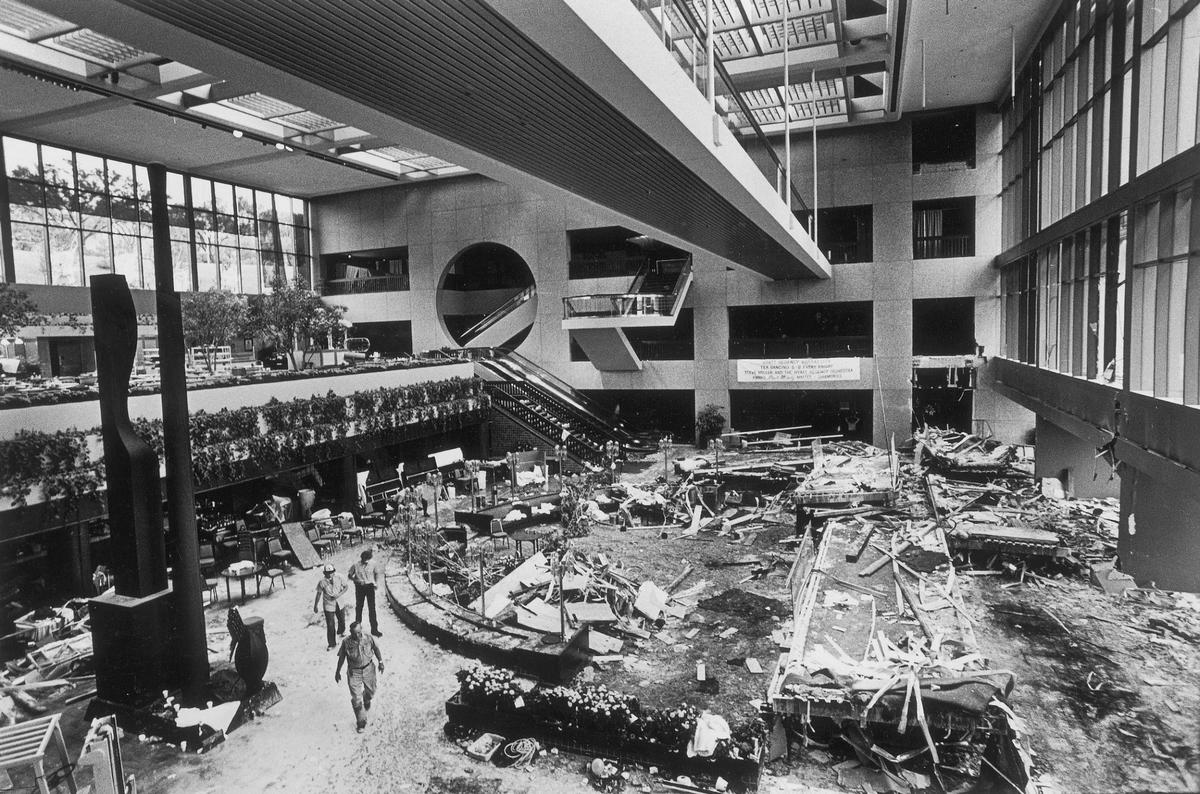 The wreckage of the second-floor and fourth-floor skywalks rests on the floor of the lobby of the Hyatt Regency Hotel after they came crashing down killing 114 people who were there to dance. The square doorway where the upper skywalk was attached can be seen in the upper right and the second-floor skywalk was two floors below that. The third-floor skywalk which did not have another skywalk attached to it and was offset from the others remained intact.