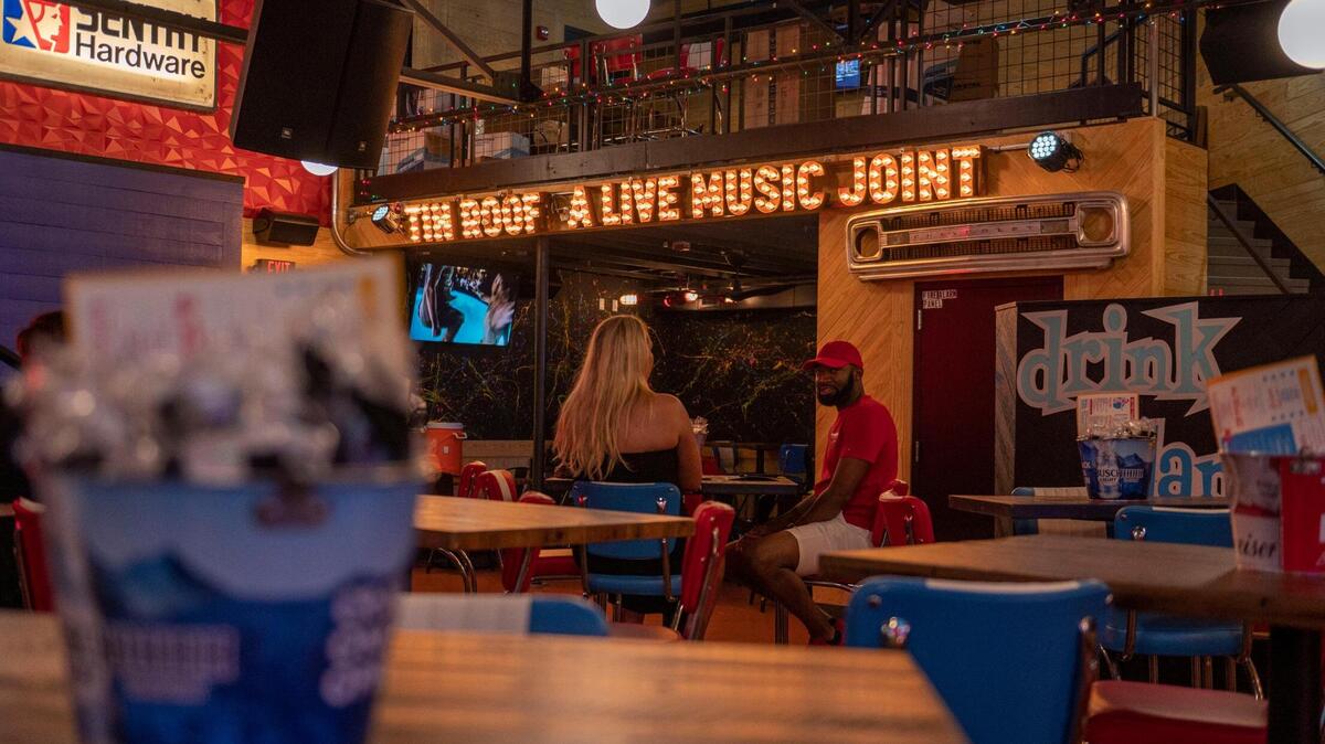 Customers wait for their orders in the indoor seating area at Tin Roof.