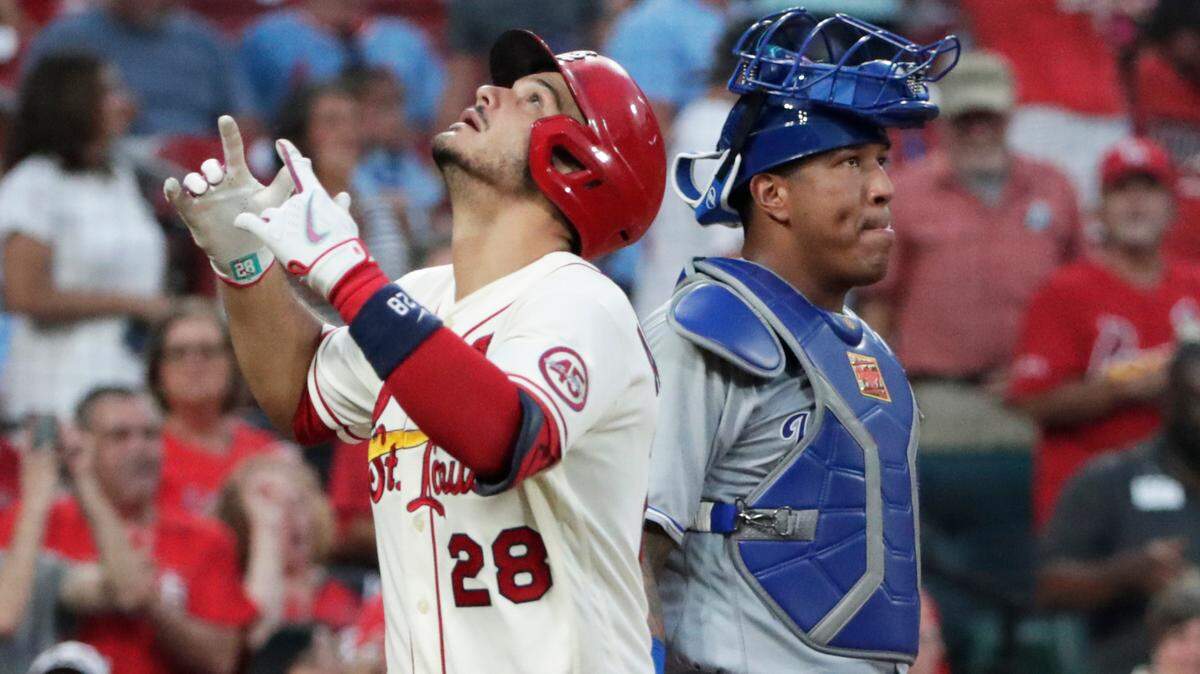St. Louis Cardinals’ Nolan Arenado (28) celebrates as he crosses home plate after hitting a solo home run next to Kansas City Royals catcher Salvador Perez during the fifth inning of a baseball game Saturday, Aug. 7, 2021, in St. Louis. (AP Photo/Tom Gannam)