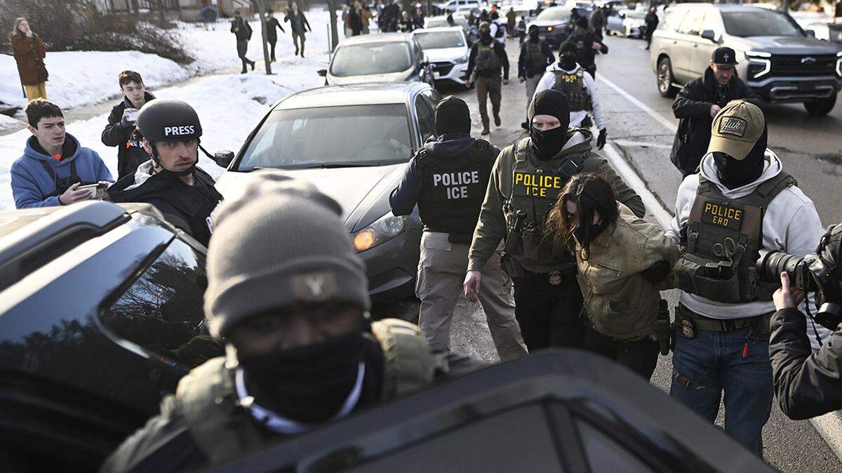 MINNEAPOLIS, MINNESOTA - JANUARY 13: An observer is detained by ICE agents after they arrested two people from a residence on January 13, 2026 in Minneapolis, Minnesota. The Trump administration has deployed over 2,400 Department of Homeland Security agents to the state of Minnesota in a push to apprehend undocumented immigrants. (Photo by Stephen Maturen/Getty Images)