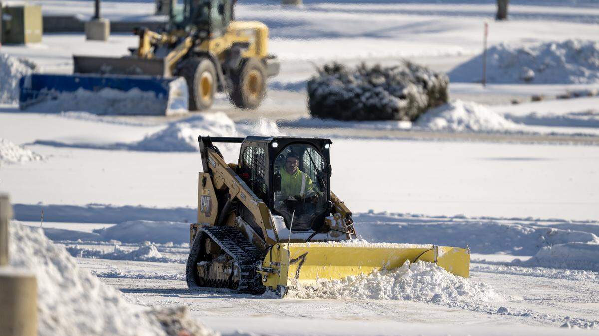 After a winter storm moved through the area, crews used heavy machinery to clear snow from the parking lot at Oak Park Mall on Sunday, Jan. 25 2026, in Overland Park.