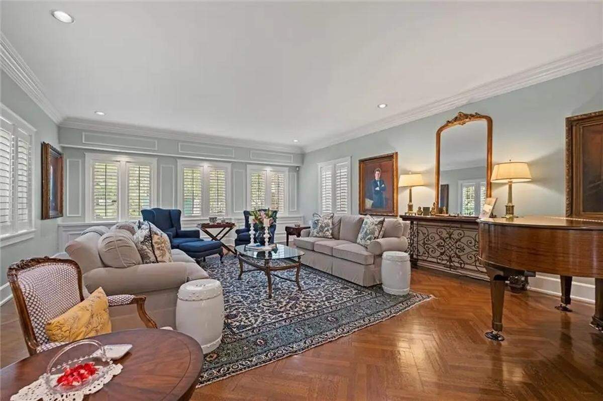 Shutters and mature trees shade the living room of a century-old home in Kansas City at 1234 W. 58th St., near Ward Parkway and Mission Hills.