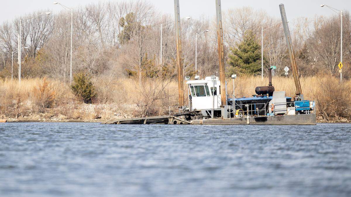A dredging watercraft floats on Legacy Lake in Lee’s Summit on Thursday, Feb. 12. Legacy Park’s 28-acre lake has lost about a third of its volume in recent years, and parks officials are aiming to restore it by removing a swath of sediment from its bottom.