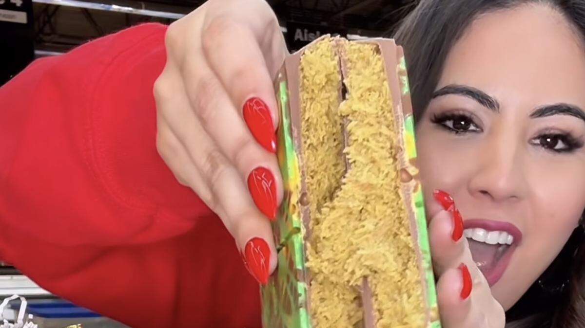 Adriana Davalos, known to her 74,000 Instagram followers as KC Lifestyle Girl, cracks open a Dubai chocolate bar at World Fresh Market in Overland Park. The viral Dubai chocolate trend has come to Kansas City.