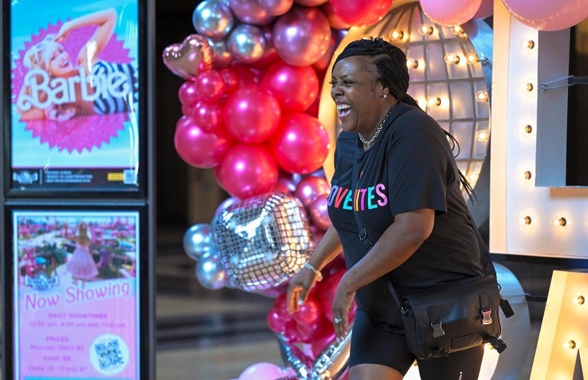 Barbie fan Kendra Morris of Kansas City, laughed after posing for photos at the Barbie-themed Alph-lit display on Thursday, July 20, 2023 at Union Station.