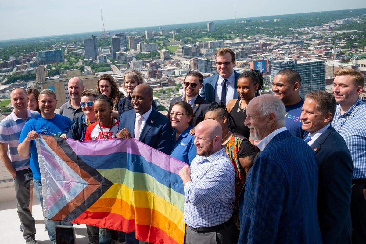City workers gather to share remarks and watch the Pride Flag be raised on the City Hall flag pole in Kansas City on June 2, 2022.