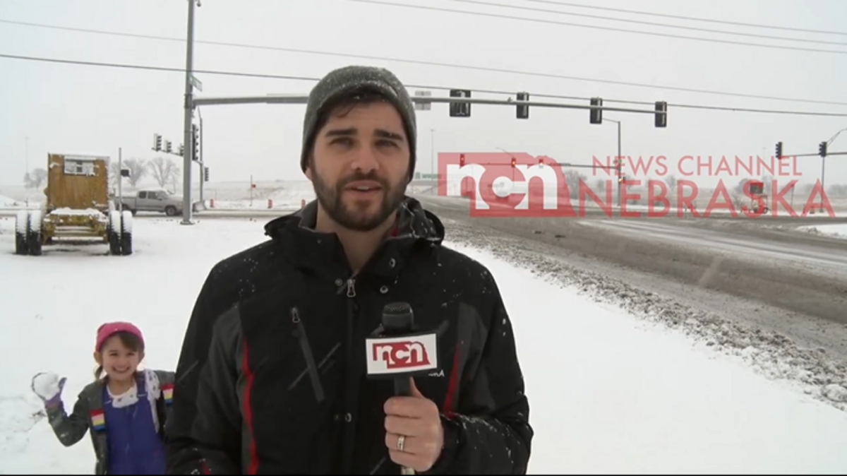 Video of the encounter shared by News Channel Nebraska shows Brandon Aksamit was covering a snowstorm when a girl appears in the camera frame with a snowball.