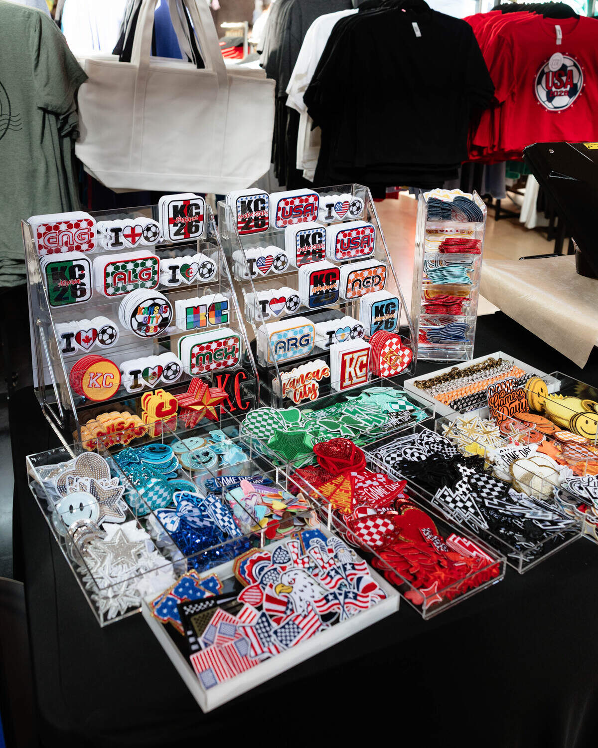 Kansas City and soccer merchandise sit out in a colorful display at City of Entrepreneurs’ launch party on June 10, 2026. Other vendors offer art, clothes, candles, gaming, food and jewelry.