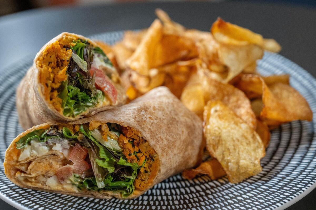 A market wrap is seen served with a side of house-made potato chips at McLain’s Market in October 2024 in Overland Park. It was one of a few restaurant visited and reviewed by British visitors.