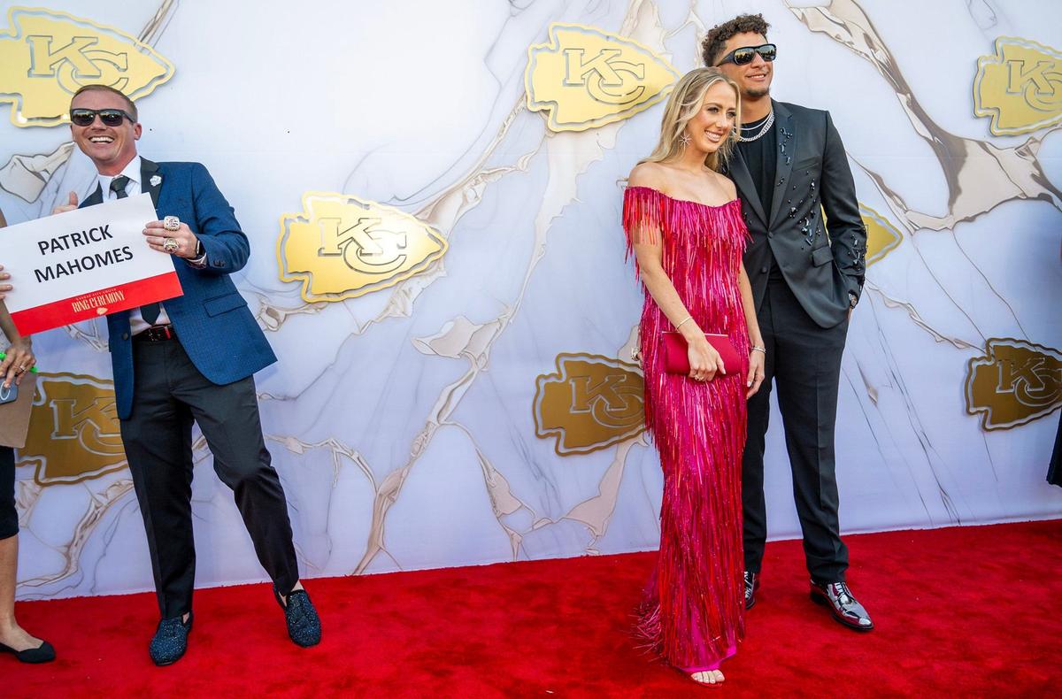 Brad Gee, left, Vice President of Football Communications, holds the name card as Chiefs quarterback Patrick and Brittany Mahomes posed on the red carpet before the Super Bowl LVIII championship ring presentation event on Thursday, June 13, 2024, at the Nelson-Atkins Museum in Kansas City.