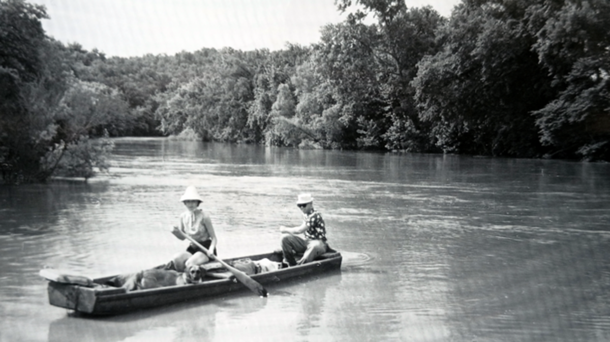 C. W. Gusewelle steadies a jon boat on a wildly flooding Niangua River in 1962.. He was starting a hazardous float with Lenore Hammer, joined moments later by Lenore’s husband, columnist Charles Hammer.