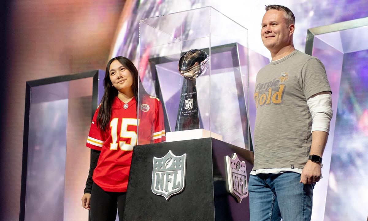 Abby and Brian Clifford of Scottsdale, Ariz., pose for a photo with the Vince Lombardi Trophy at the NFL’s Super Bowl Experience on Thursday, Feb. 9, 2023, in Phoenix.