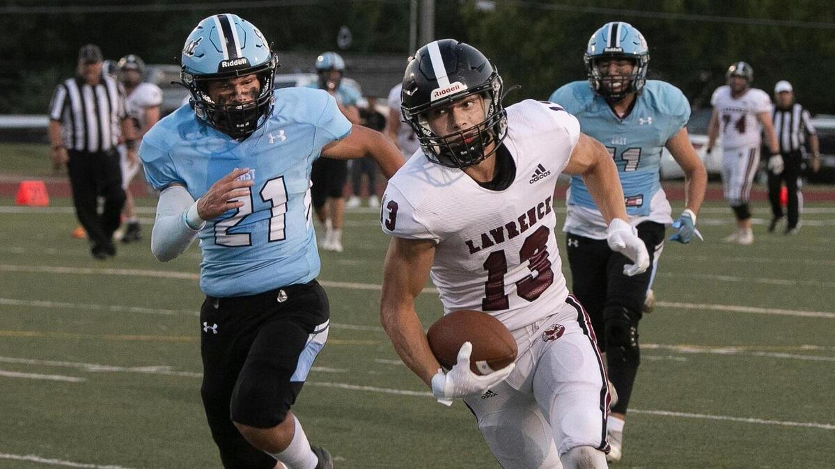 Dominic Ostronic #13 of Lawrence carried the ball during the game against Shawnee Mission East Friday, September 16, 2022 at the Shawnee Mission district stadium at Shawnee Mission North. Lawrence was ahead at the half 19-7.