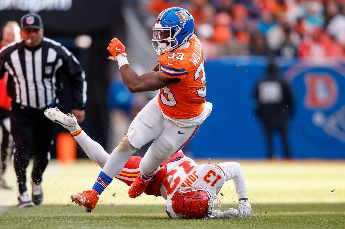 Broncos running back Javonte Williams runs through the would-be tackle of Kansas City Chiefs cornerback Nic Jones during the teams’ NFL Week 18 game at Empower Field at Mile High in Denver on Sunday, Jan. 5, 2025.