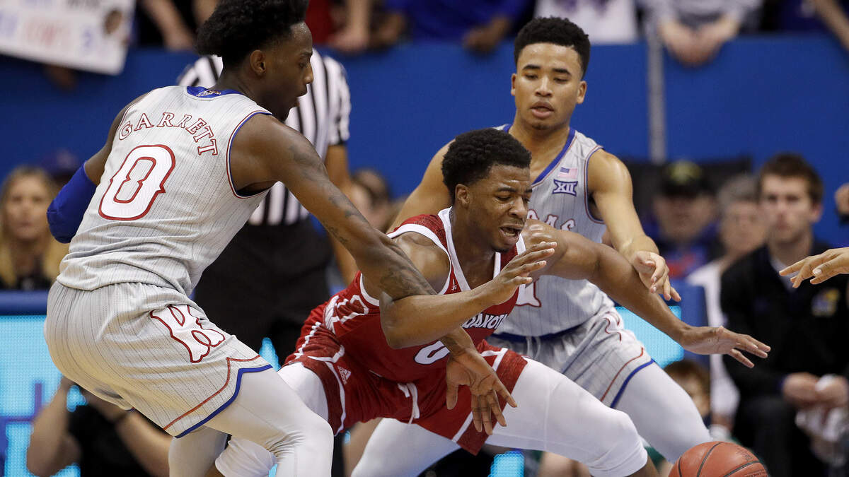 Kansas’ Marcus Garrett, left, and Devon Dotson try to strip the ball from South Dakota’s Stanley Umude Tuesday night in Lawrence.