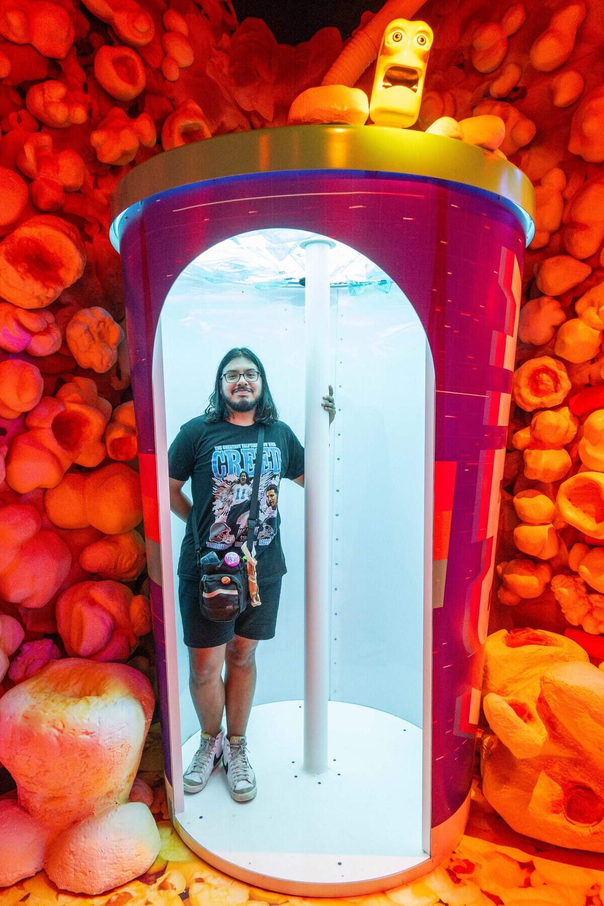 The Star's Joseph Hernandez stands inside a cup in a room made of popcorn at Atlas 9, on Wednesday, Sep. 3, 2025, in Kansas City, Kansas. Designed by Kansas City-based industrial design company, Dimensional Innovations, Atlas 9 is a narrative-driven immersive art experience featuring interactive games, videos, and AI-powered experiences.