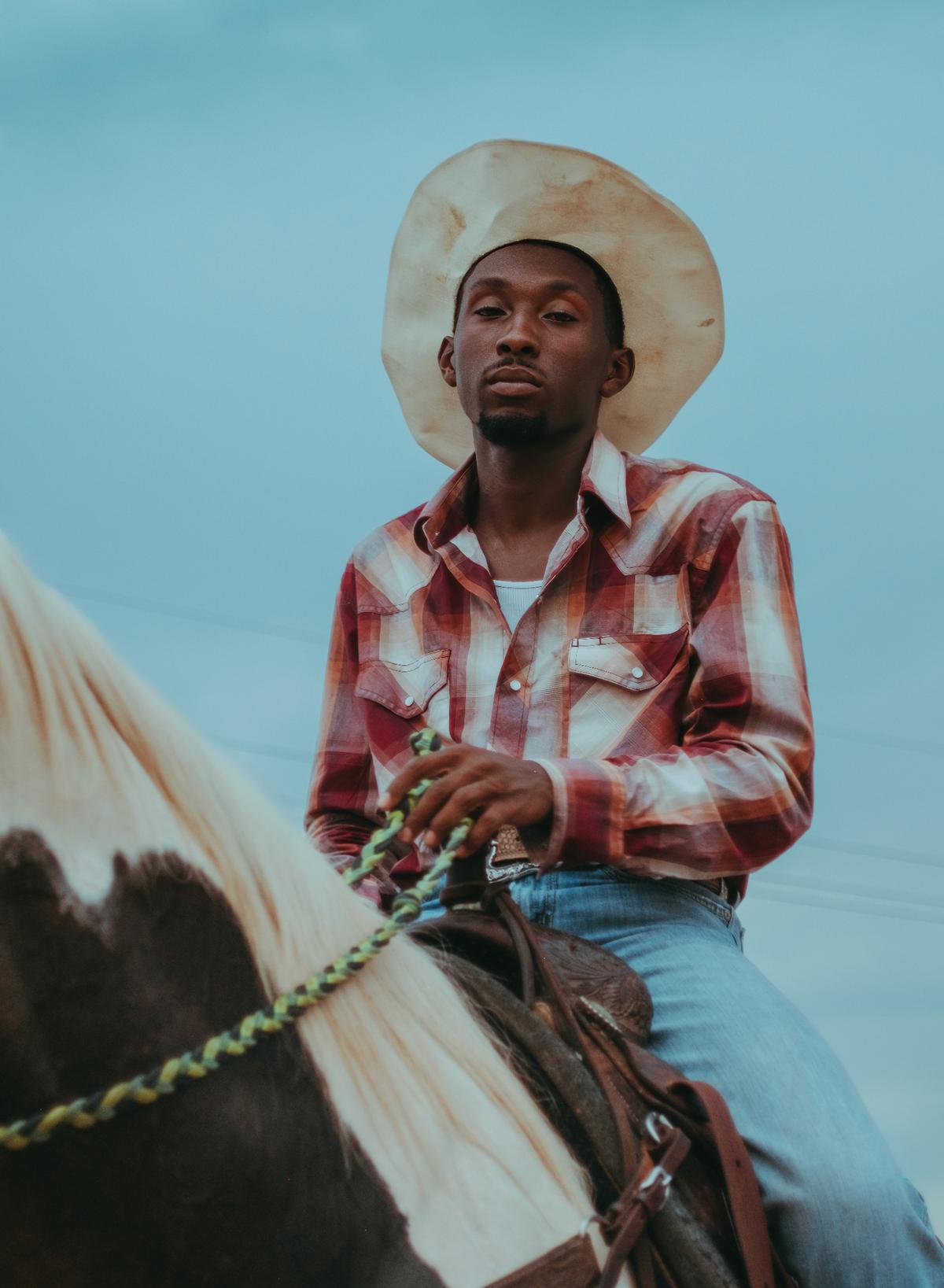 Photo taken by Ivan McClellan of Black a cowboy riding a horse at one of the many rodeos he has photographed over the years documenting Black rodeos in the United States.