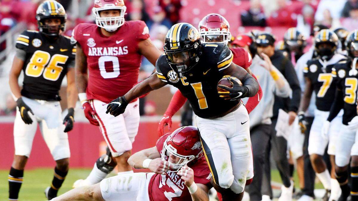 Missouri running back Tyler Badie (1) is knocked out of bounds by Arkansas defensive back Hayden Henry (27) during an NCAA college football game Friday, Nov. 26, 2021, in Fayetteville, Ark. (AP Photo/Michael Woods)