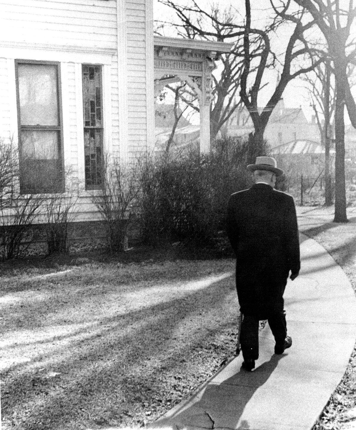 Former President Harry S. Truman returns to his home in Independence, Missouri, in 1953, cane in hand, after one of his famous talks in town.