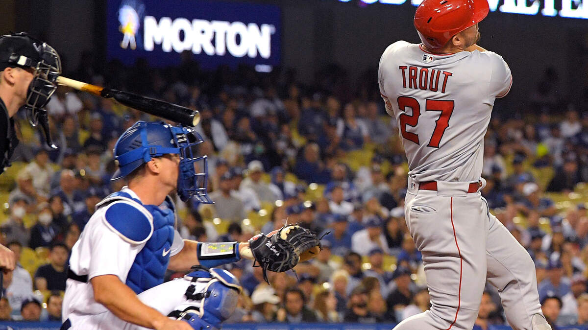 Home plate umpire Nate Tomlinson, left, is hit in the face with a broken bat after Los Angeles Angels’ Mike Trout, right, hits a single as Los Angeles Dodgers catcher Will Smith watches during the ninth inning of a baseball game Tuesday, June 14, 2022, in Los Angeles. Tomlinson was injured and need to be helped off the field. (AP Photo/Mark J. Terrill)